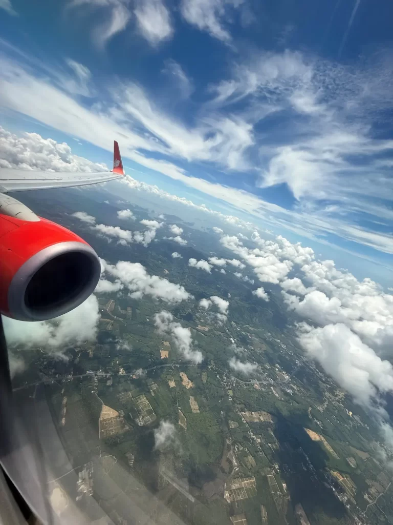 Island coastline and clouds viewed from plane window approaching Phuket