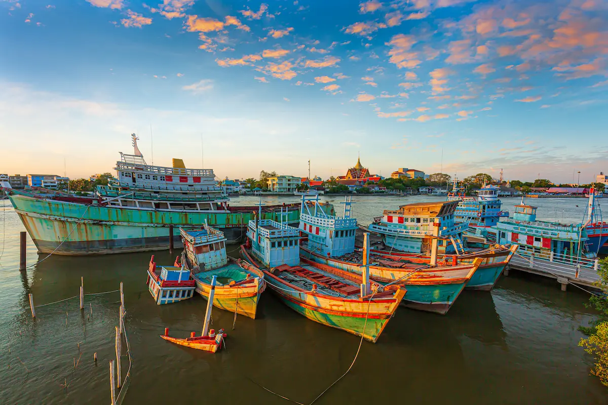 Traditional Thai fishing boats moored at a Phuket pier — vibrant local scene before a phi phi islands tour