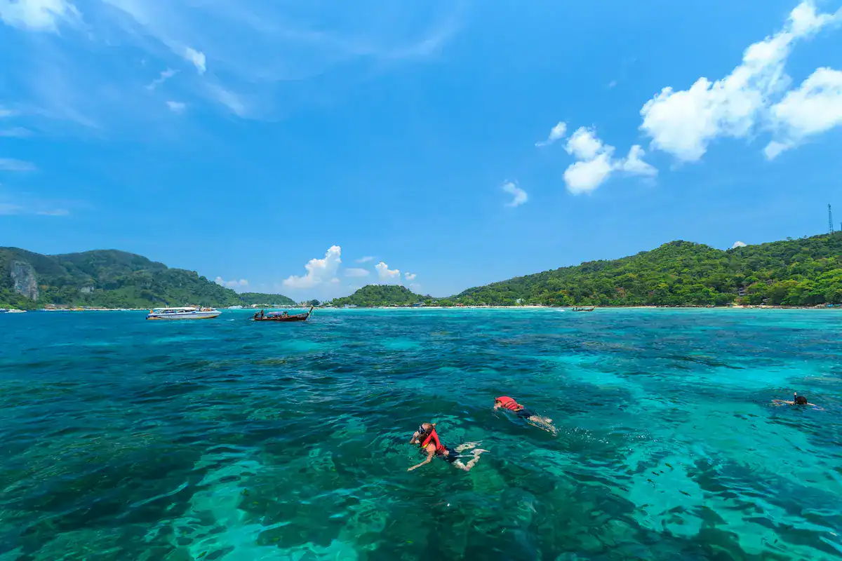 Travelers snorkeling above clear coral reefs near Khai Island on a Phi Phi and Khai Islands day tour from Phuket