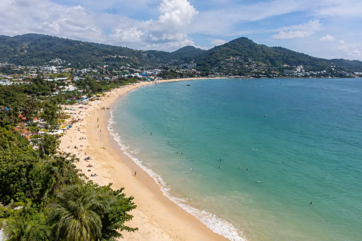 Kamala Beach Phuket showing a wide curved beach with light activity and a relaxed atmosphere
