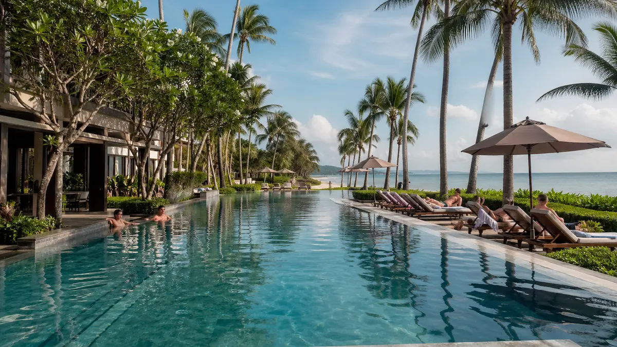 Luxury beachfront resort swimming pool near Mai Khao Beach Phuket with palm trees loungers and ocean views