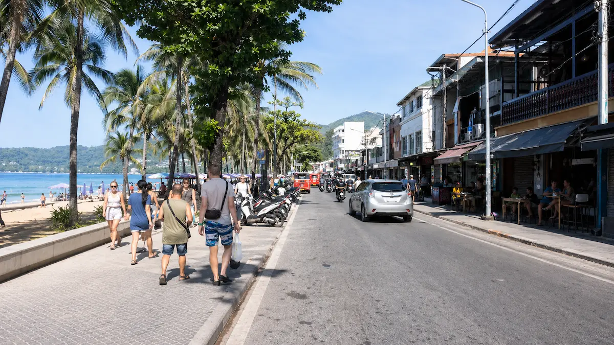 Patong Beach Road Phuket with tourists walking near beach cafes shops and street activity
