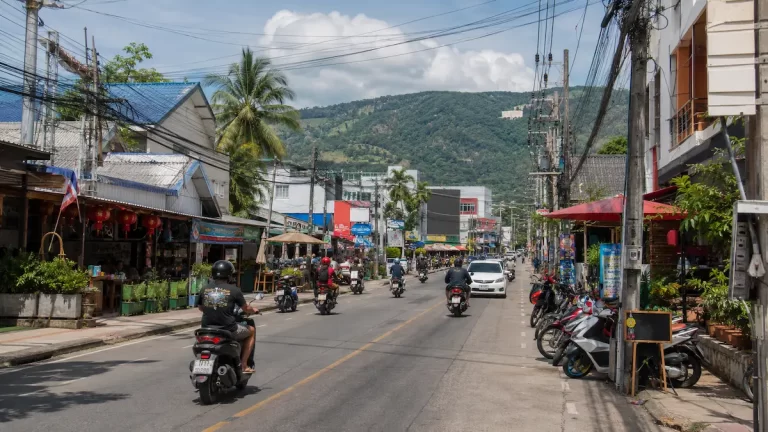 Busy street scene in Chalong Phuket with scooters and local businesses