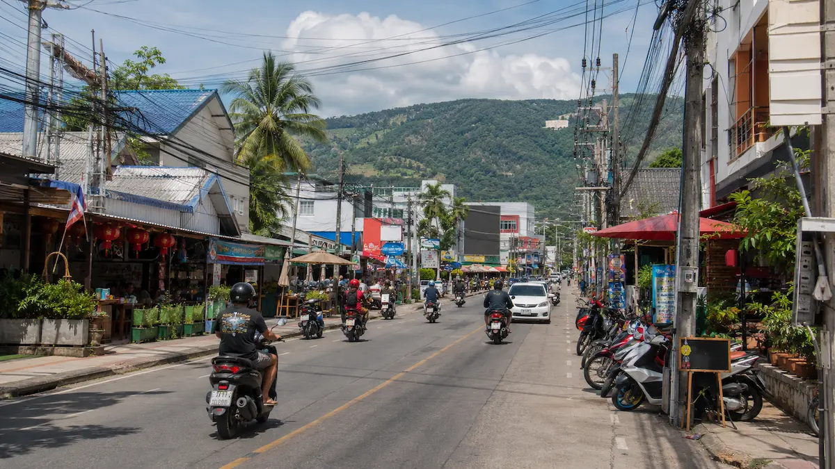 Busy street scene in Chalong Phuket with scooters and local businesses