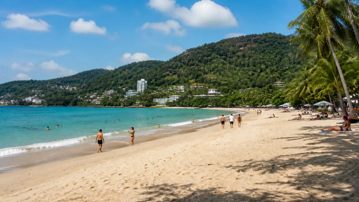 Phuket beach scene with tourists walking and swimming showing typical travel experience