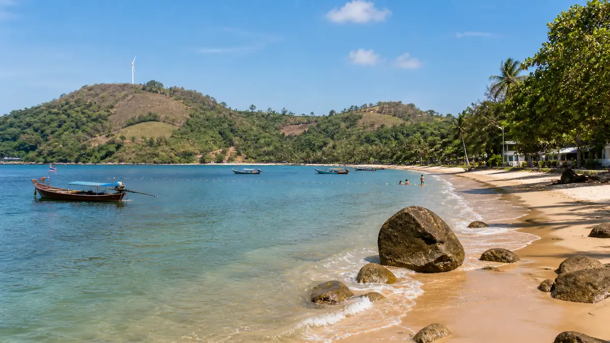 quiet Phuket beach with longtail boats showing relaxed travel and longer stay experience