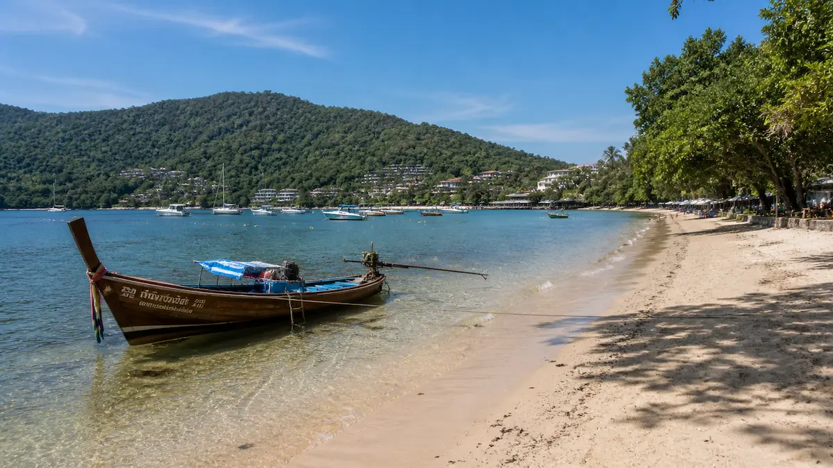 Rawai Beach Phuket with longtail boat showing calm and safe local coastal environment stylised for is phuket safe guide