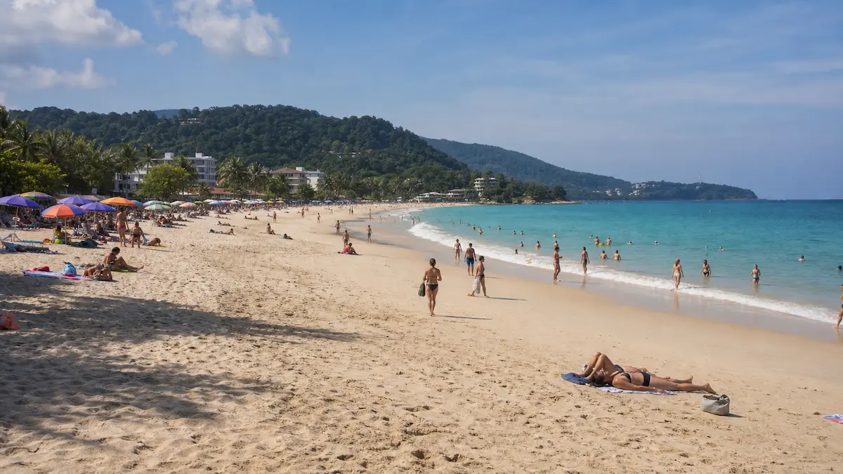 Busy day at Kata Beach Phuket showing people swimming relaxing and active beach atmosphere