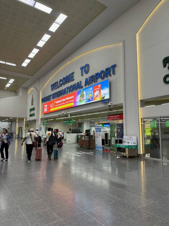 Phuket airport private transfer arrival hall with travellers and luggage at Phuket International Airport