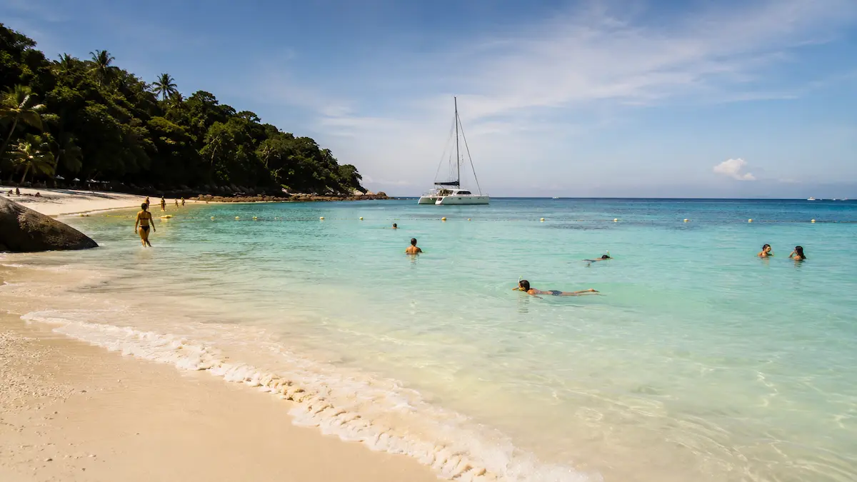 Travelers swimming during a relaxed Phuket island tour at Racha Island with calm turquoise water and slower tropical atmosphere
