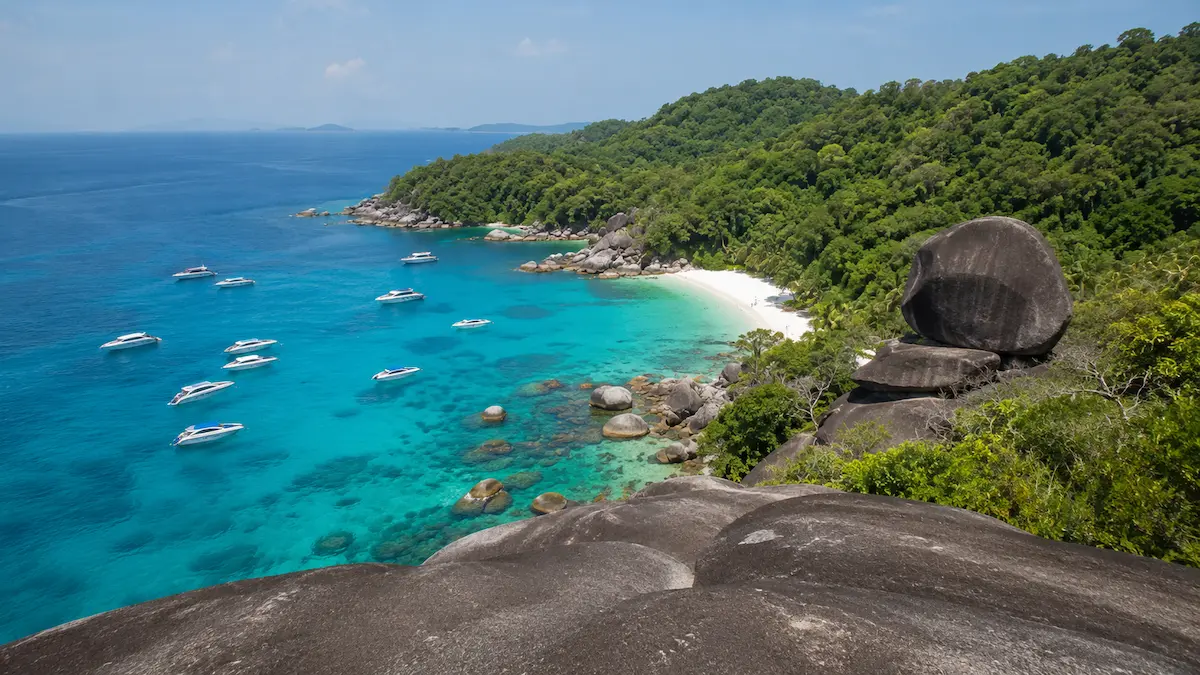 View from Sail Rock overlooking turquoise water and speedboats in the Similan Islands Thailand