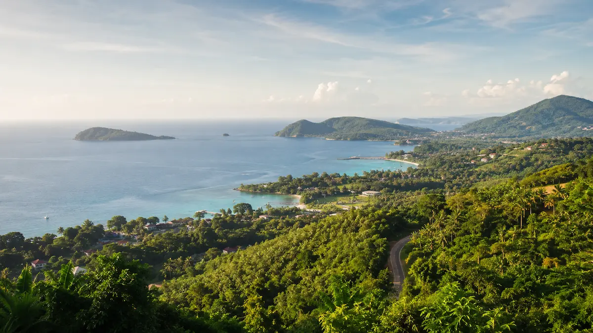 Scenic coastal view of South Phuket with green hills, quiet bays, blue water and tropical coastline near Rawai, Nai Harn, Chalong and Cape Panwa.