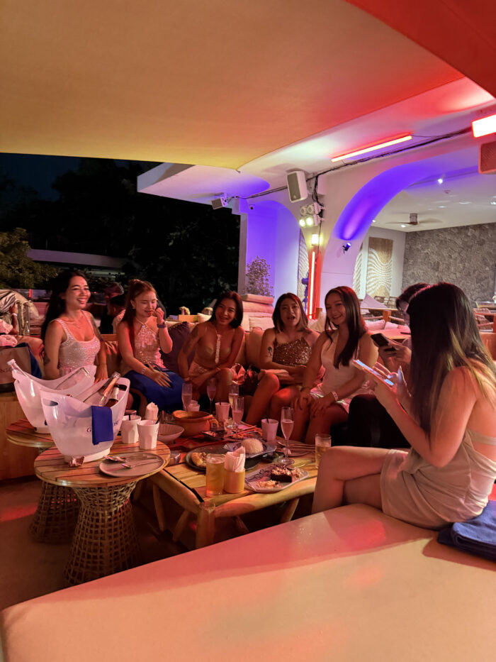 Guests relaxing around lounge seating at Fira Beach Club Phuket